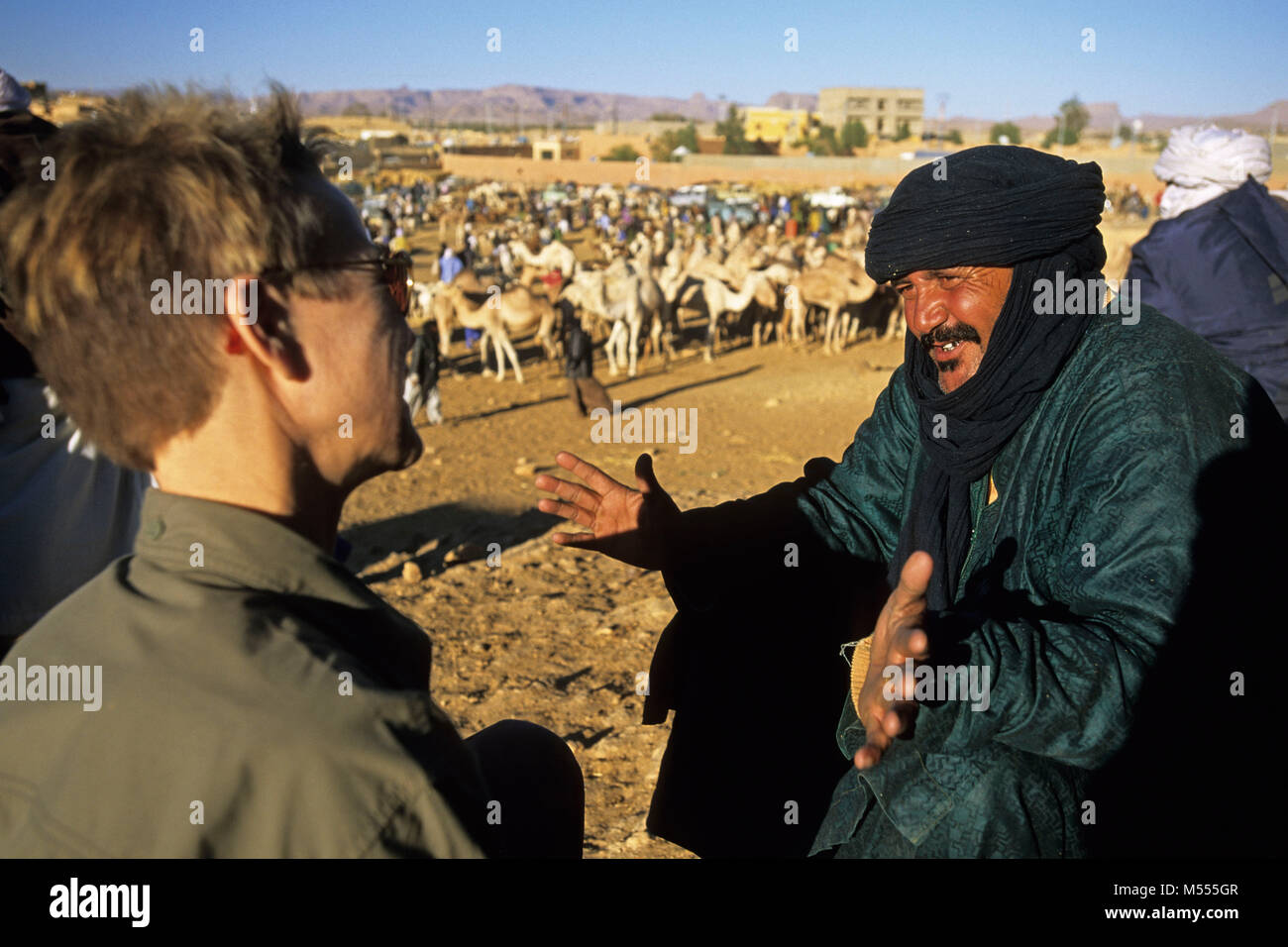 In Algeria. Tamanrasset. Deserto del Sahara. Mercato di cammelli. Camel-driver e turistico, donna. Foto Stock