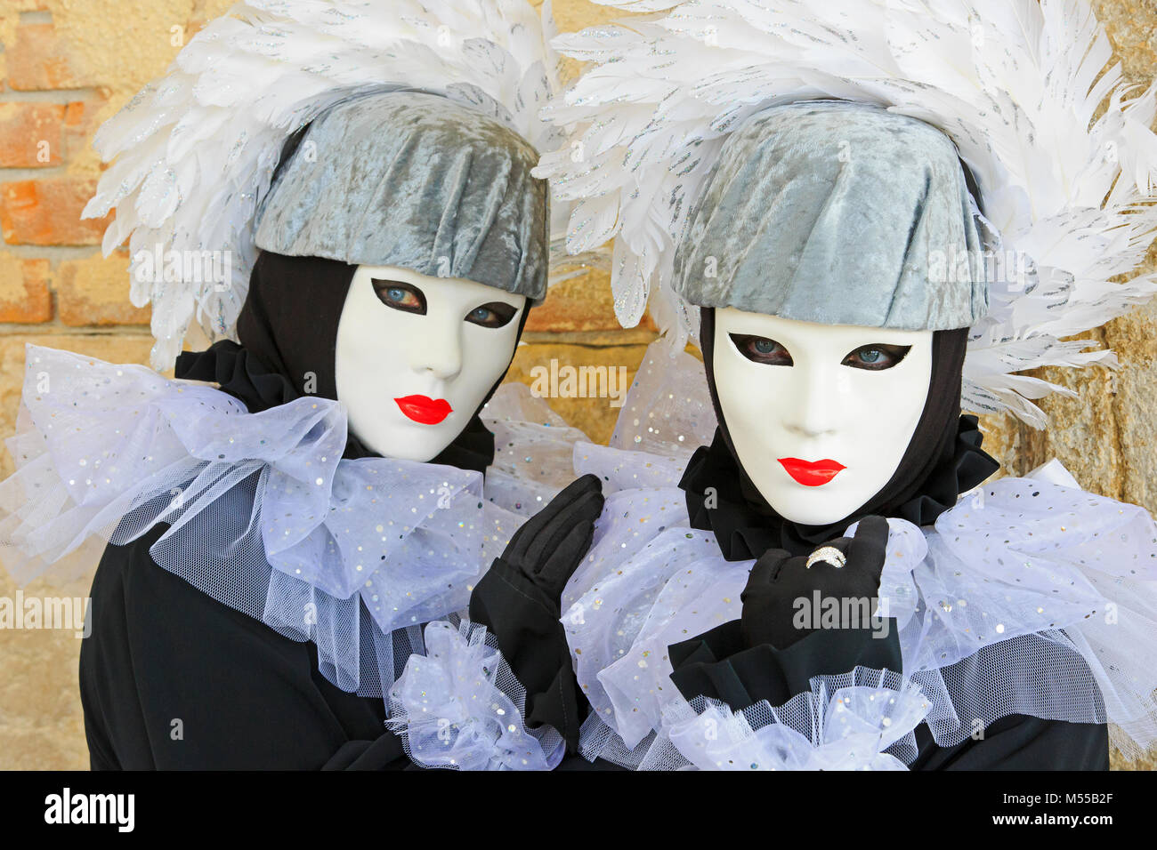 Gemelle vestito come arlecchini al di fuori del Palazzo del Doge durante il Carnevale di Venezia (Carnevale di Venezia) a Venezia, Italia Foto Stock