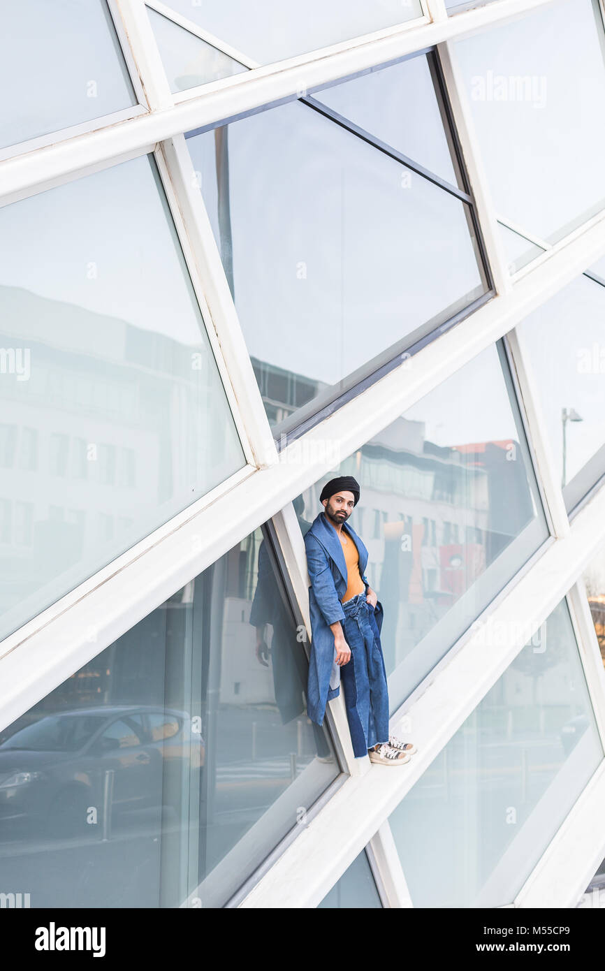 Bel uomo indiano che pongono in un contesto urbano. Street Moda e stile. Foto Stock