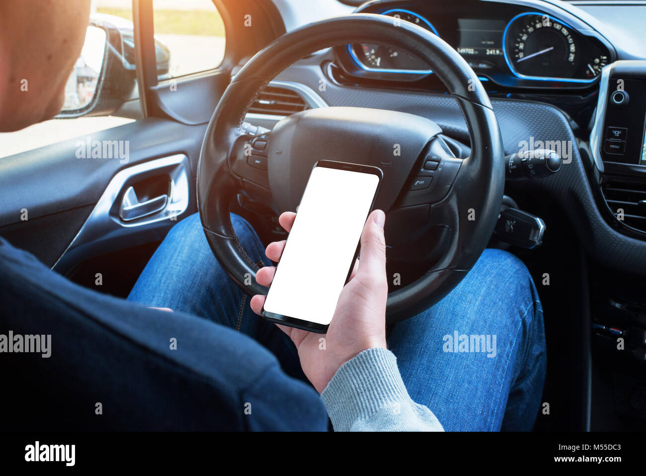 Uso del driver smart phone in auto. Schermo isolato per mockup. Moderni interni auto in background. Foto Stock