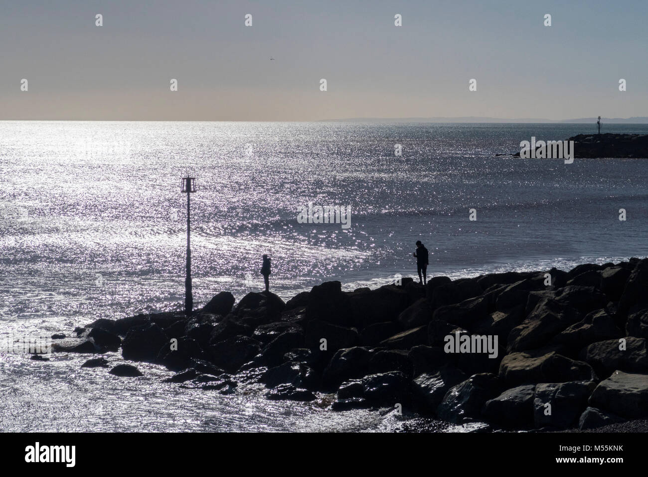 Sidmouth, Devon, xx febbraio 18. Regno Unito Meteo: giocare i bambini sulla roccia pennelli a Sidmouth Beach, bagnata dal caldo sole come la molla sposta in, e in inverno si sposta fuori. Credit: Foto centrale/Alamy Live News Foto Stock