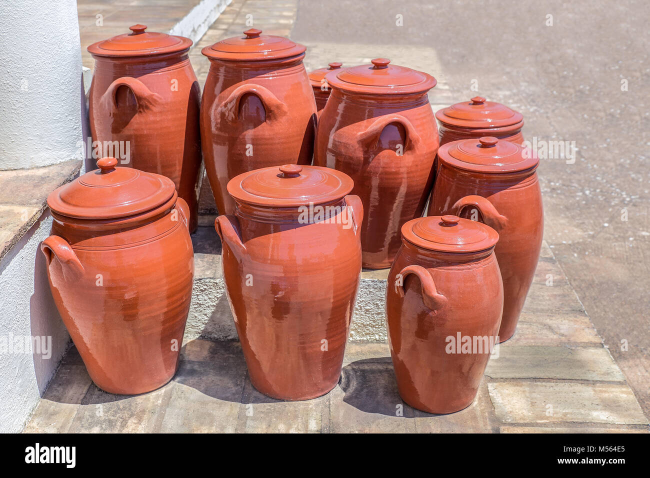 Numerosi vasi di argilla sul pavimento esterno in ceramica Foto Stock