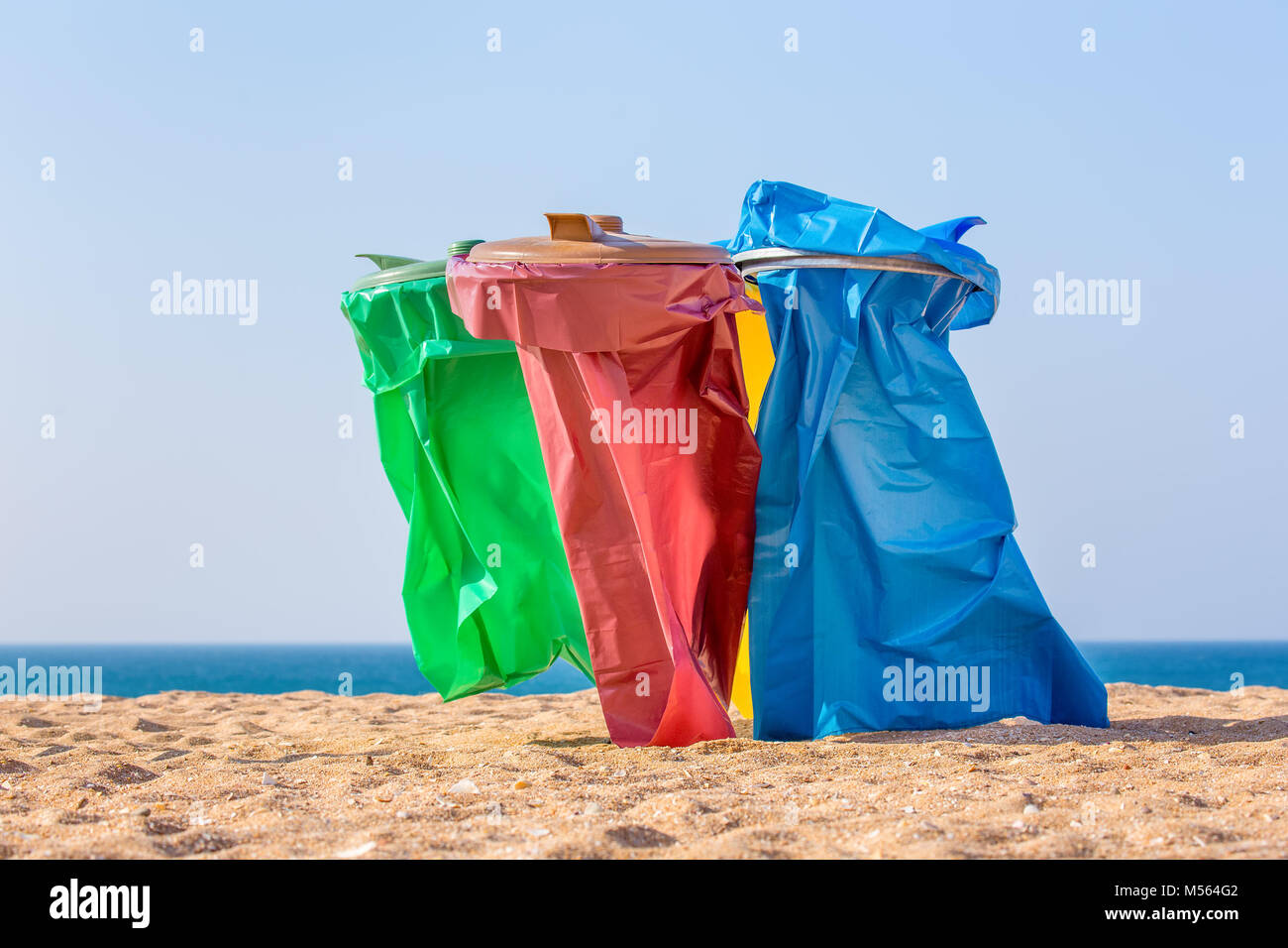 Colorato sacchi della spazzatura sulla spiaggia di Costa Foto Stock