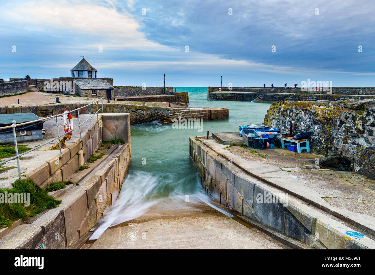 Charlestown Harbour come le nuvole in rotolo e il mare arriva fino al porto di uno scalo al crepuscolo. La vista è dal porto guardando verso est attraverso a t Foto Stock