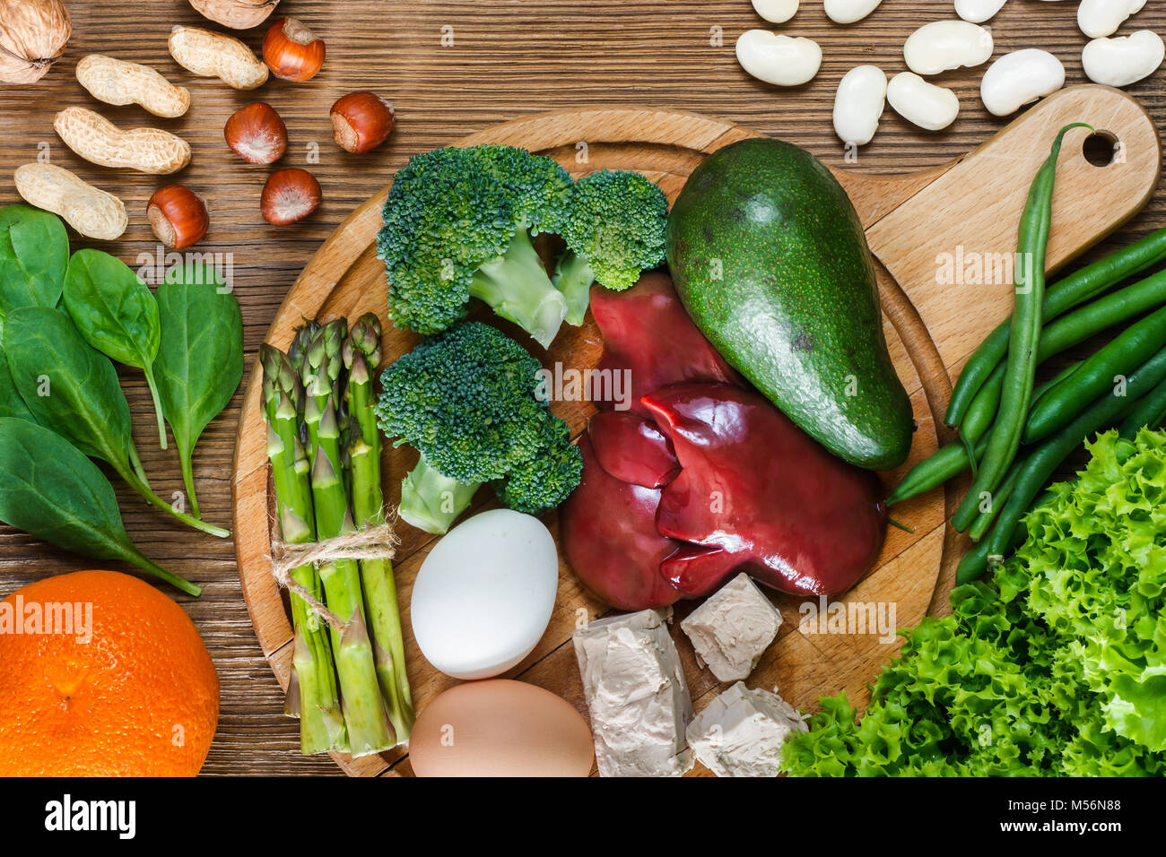 Fonti naturali di acido folico come fegato, asparagi, broccoli, uova, insalata di avocado, lievito, dadi, spinaci, arancione e fagioli Foto Stock