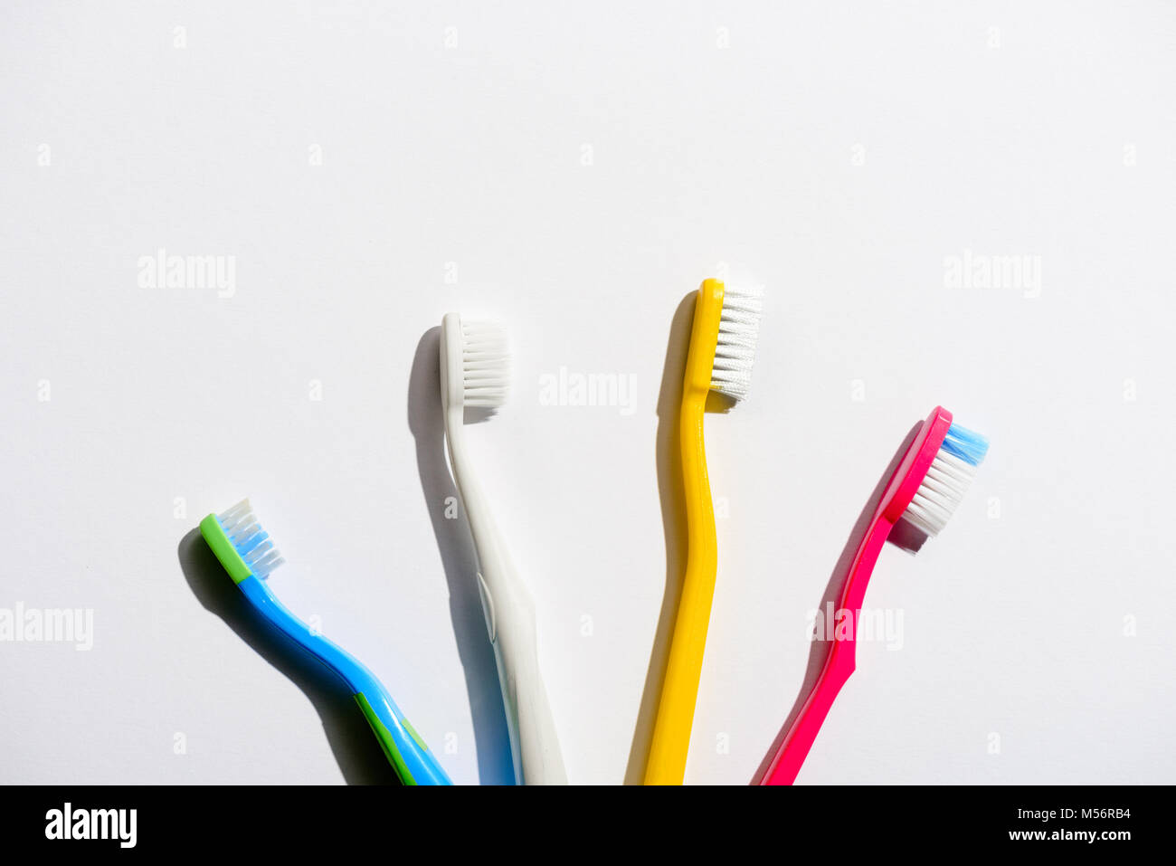 Quattro spazzolini da denti colorati per mattina igiene, su bianco Foto Stock