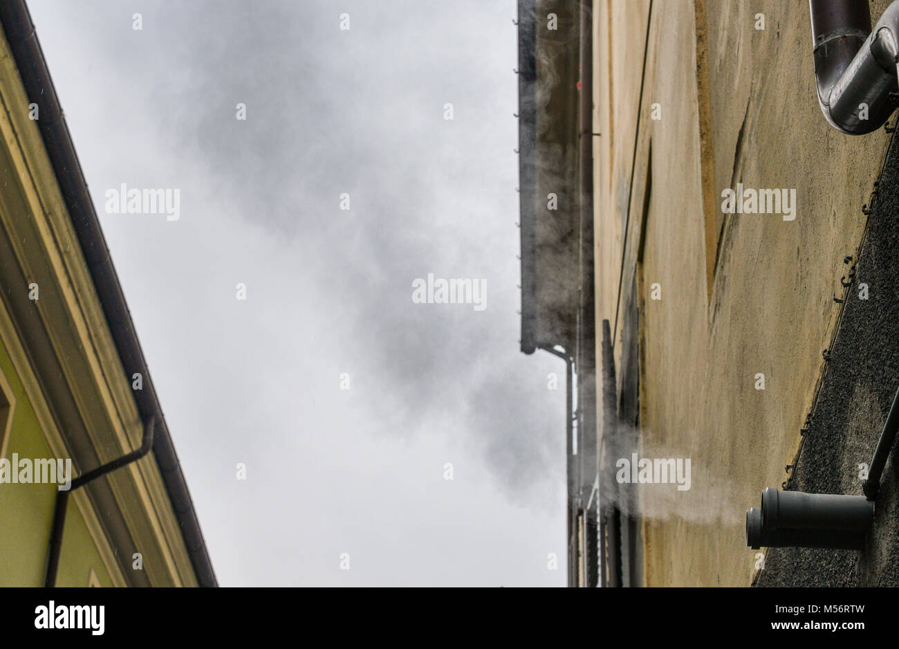Il vapore caldo proveniente da una casa residenziale del tubo durante il tempo freddo Foto Stock