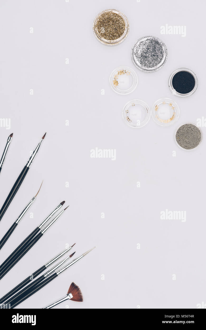 Vista superiore delle spazzole e glitter isolato su bianco Foto Stock