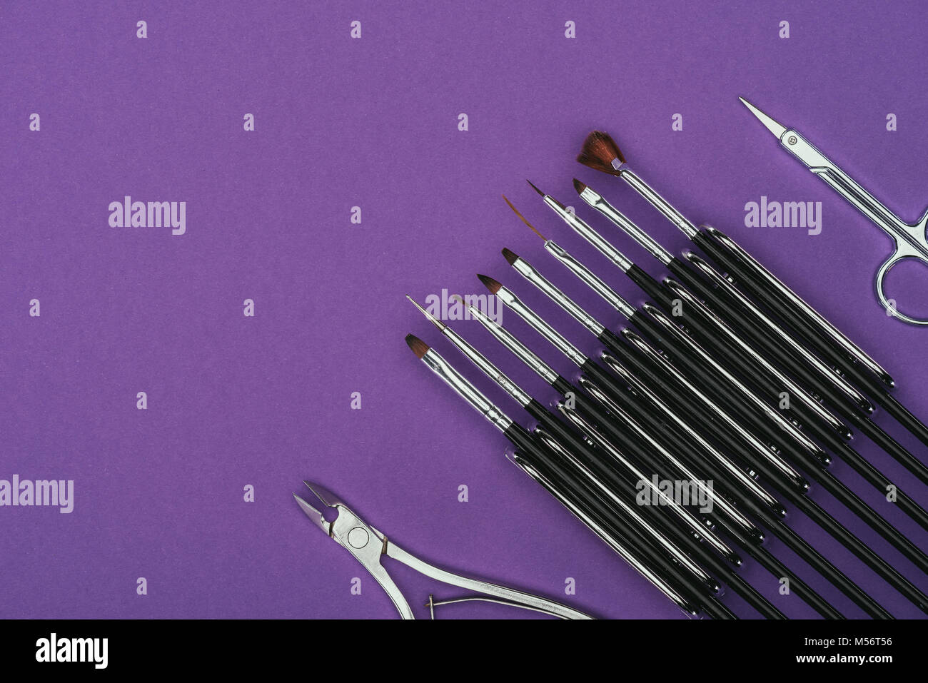 Vista superiore delle spazzole, forbici e chiodo pinze isolate su viola Foto Stock