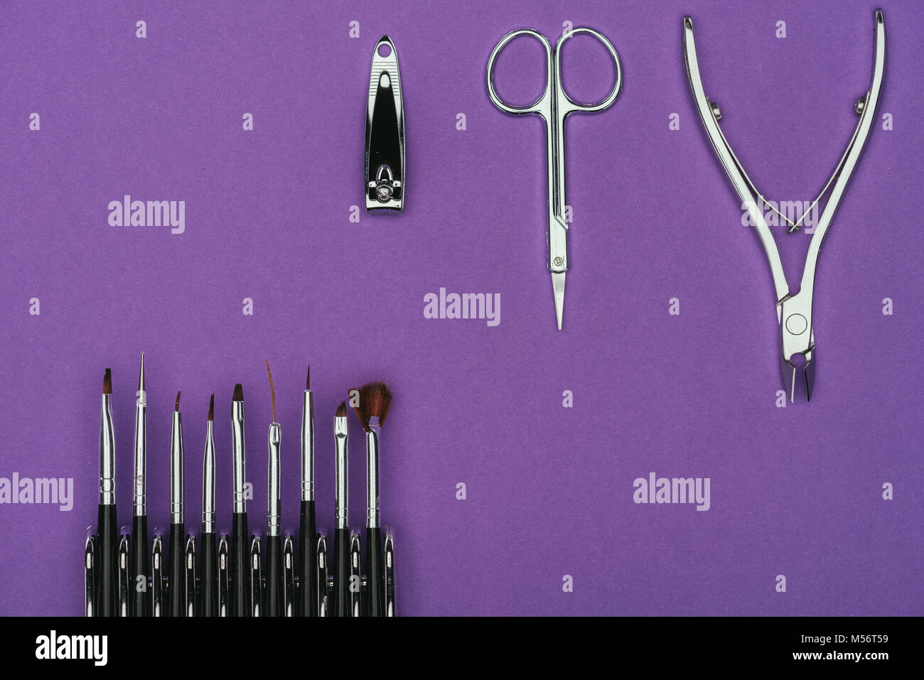 Vista superiore delle spazzole e manicure strumenti isolati su viola Foto Stock