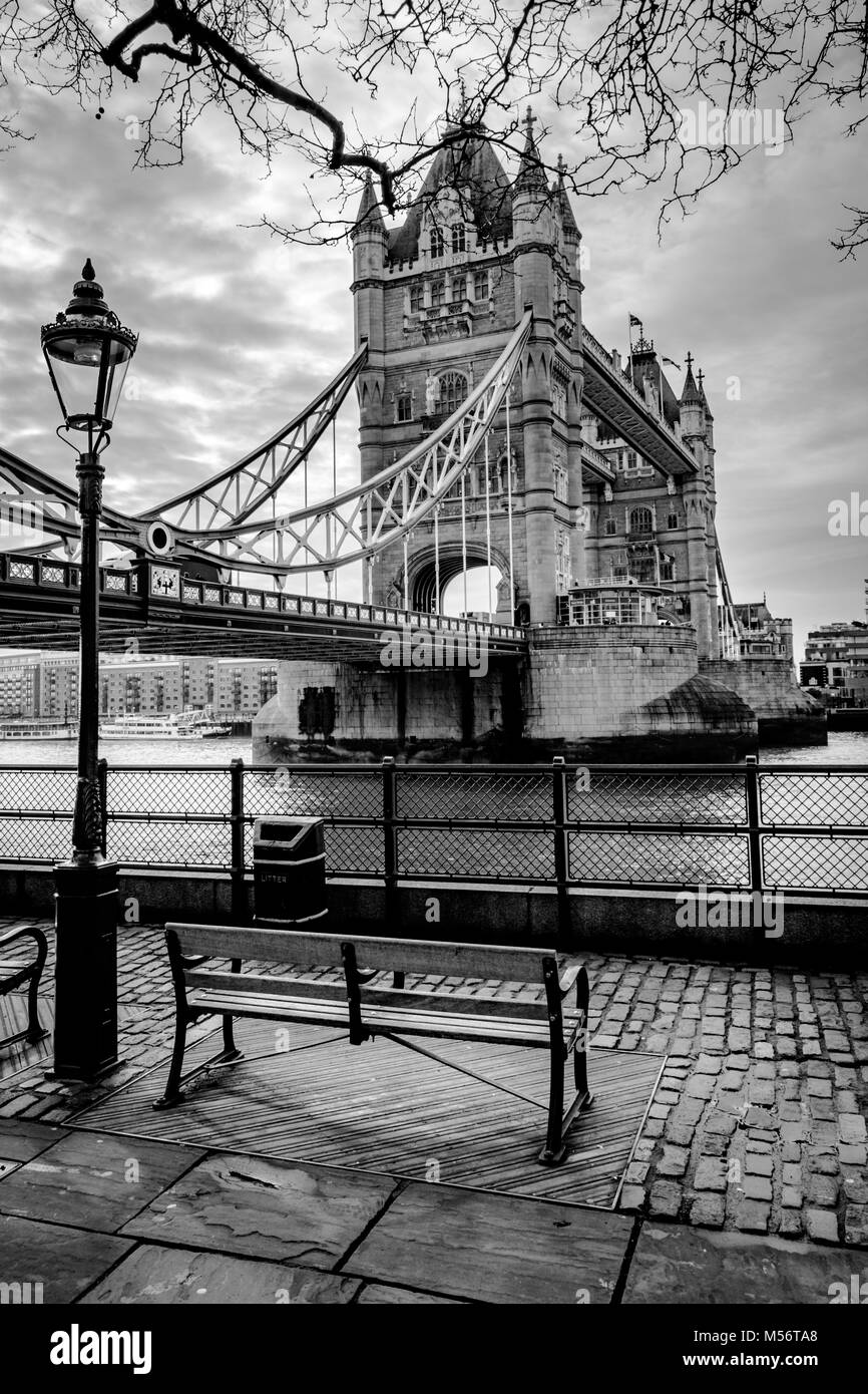 Foto in bianco e nero a guardare il Tower Bridge e il fiume Tamigi a Londra. Un buon posto per sito su una panchina nel parco e guardare la vita del mondo. Foto Stock