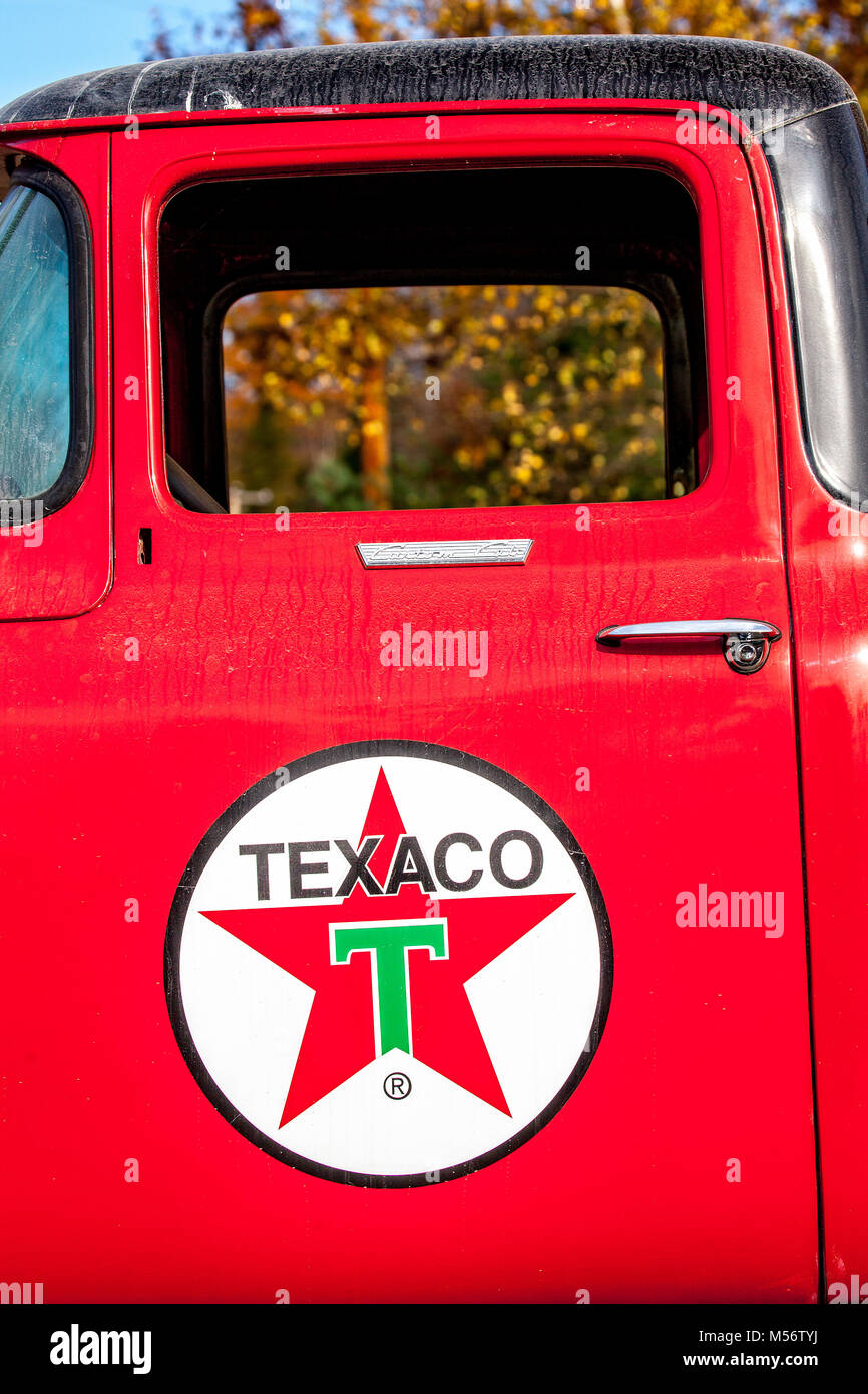 Vintage anni quaranta Texaco pompa a gas e olio può logo stampato su un rosso carrello porta. Foto Stock