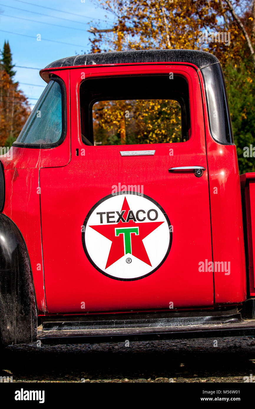 Vintage anni quaranta Texaco pompa a gas e olio può dettagliata del logo su uno sportello di un restaurato, rosso pickup. Foto Stock