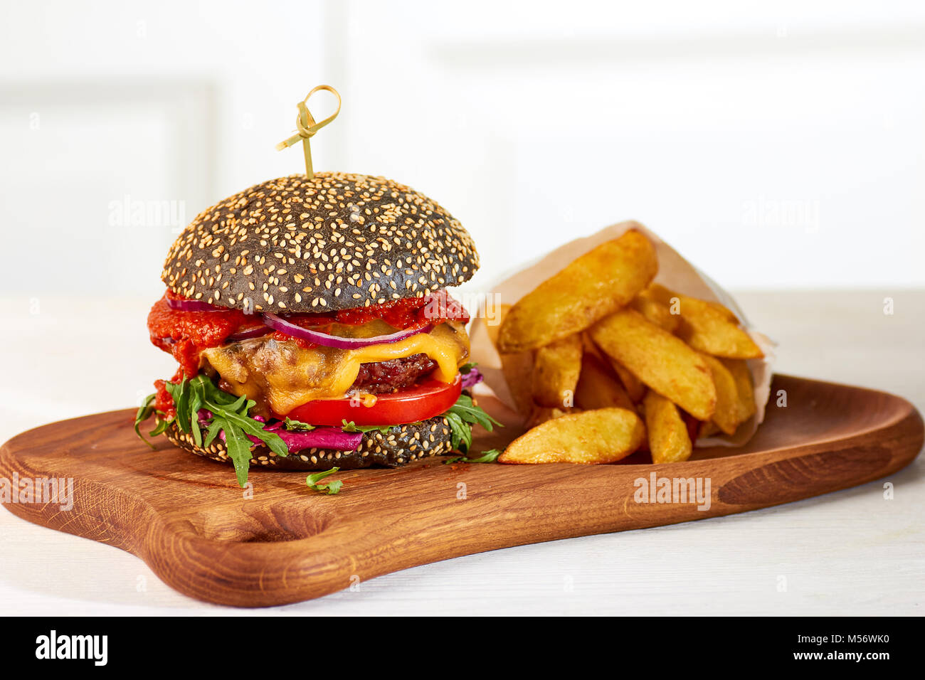 Nero cheeseburger e patatine Foto Stock