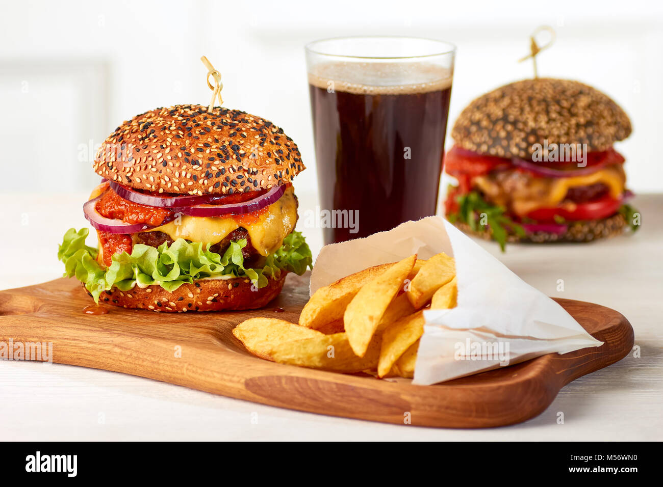 Due hamburger con patatine e un bicchiere di coca cola Foto Stock