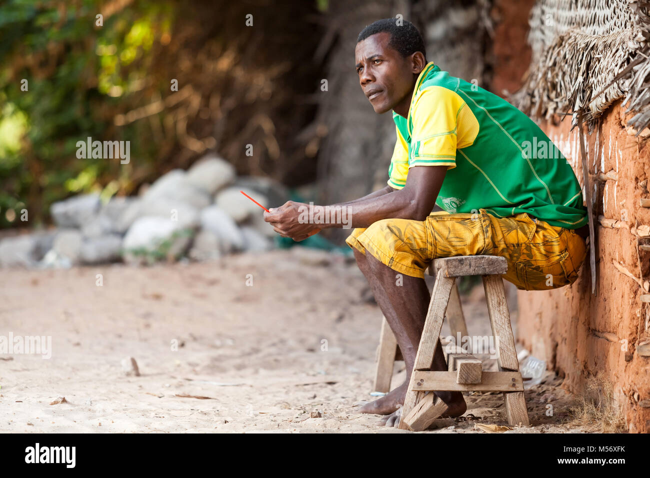 Stone Town Zanzibar - Gennaio 20, 2015: uomo seduto sulla panca di legno cercando di distanza Foto Stock