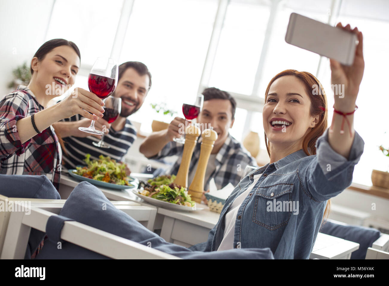 Avvisare gli amici prendendo un selfie e bere il vino Foto Stock