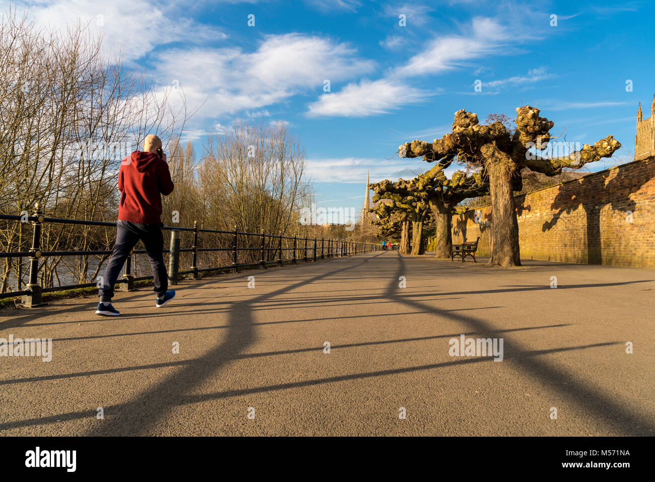 Bassa angolazione di un uomo a piedi lungo il sentiero lungo il fiume Severn a Worcester, Regno Unito Foto Stock
