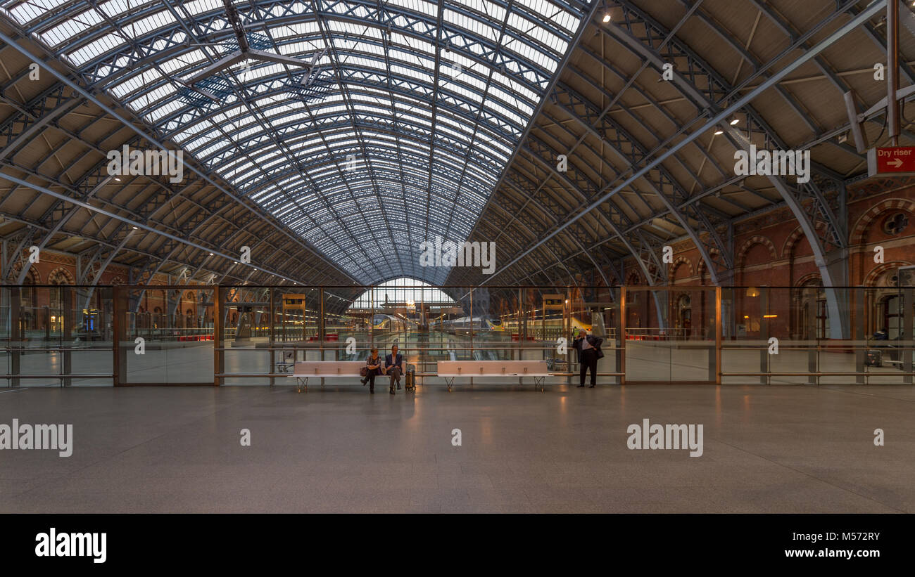 La stazione di St Pancras interno soffitto a cupola con coppia in attesa: Londra, Regno Unito Foto Stock