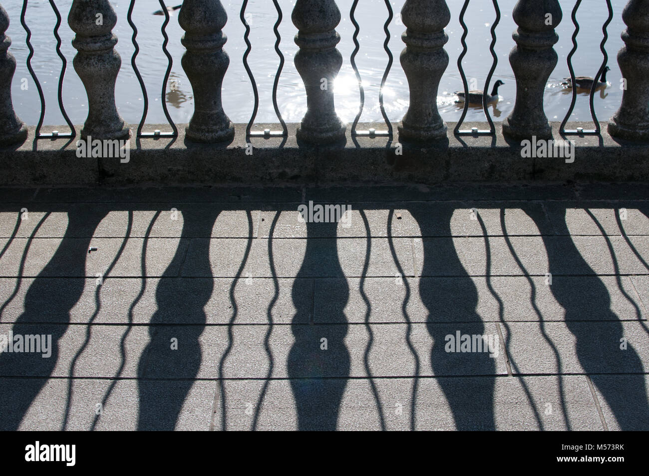 Balaustra in pietra e le ombre sul fiume Foto Stock