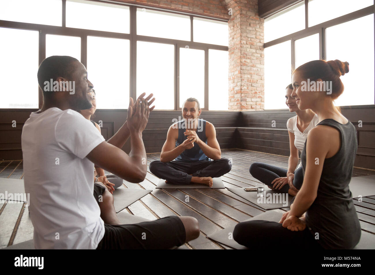 Emozionato afro-americano a parlare con diversi amici seduti Foto Stock