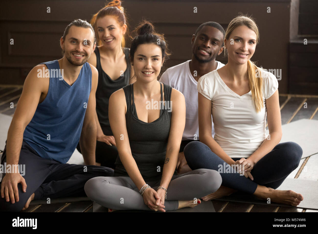 Istruttore Yoga posa con multirazziale di persone in formazione di gruppo Foto Stock