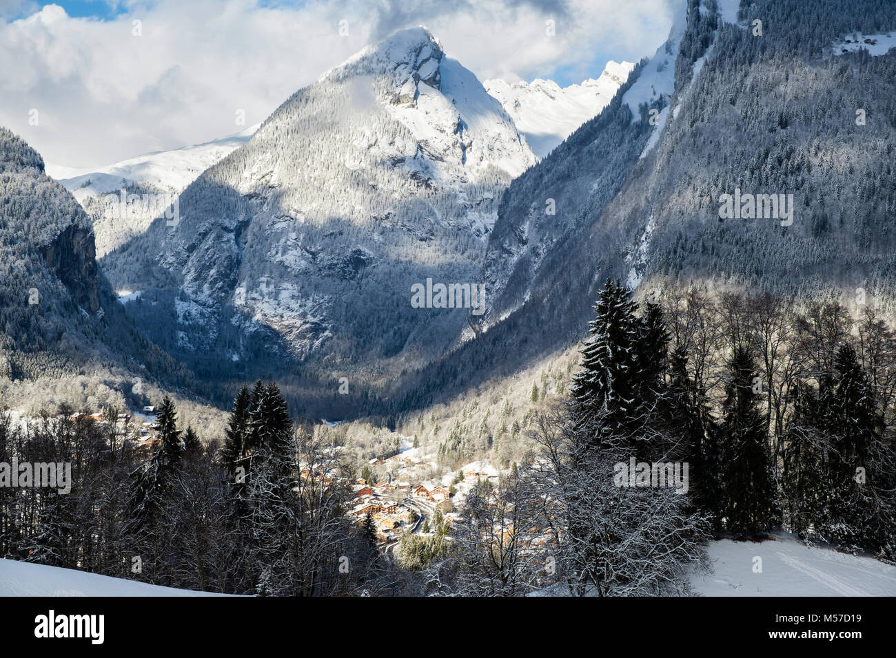Vista dal fianco della montagna con la neve sulle montagne nelle Alpi francesi al di sopra del villaggio Samoens, Vallée du Giffre, Haute Savoie, Rhone-Alpes, Francia, Eur Foto Stock
