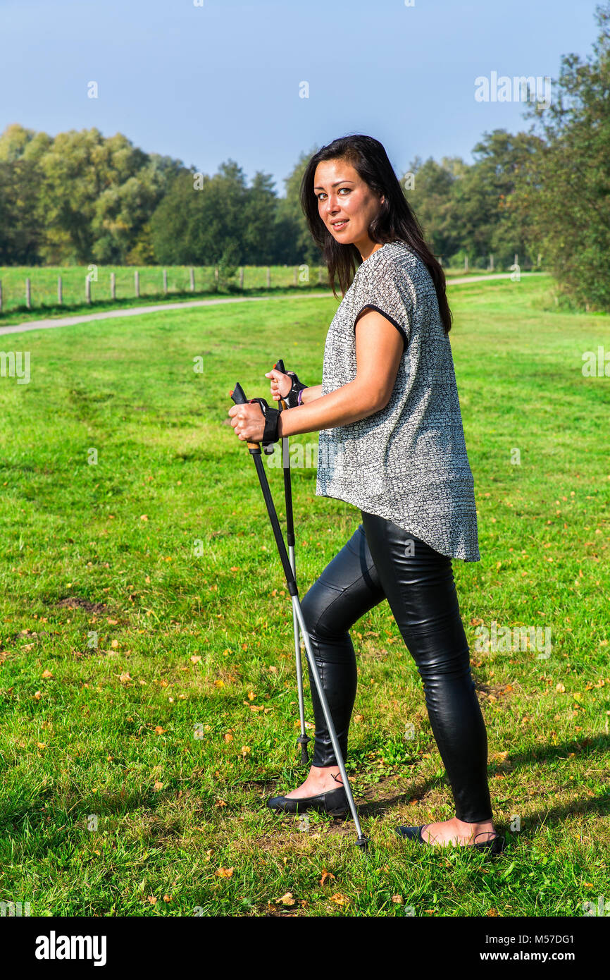 Donna escursionismo con bastoncini Nordic Walking Foto Stock