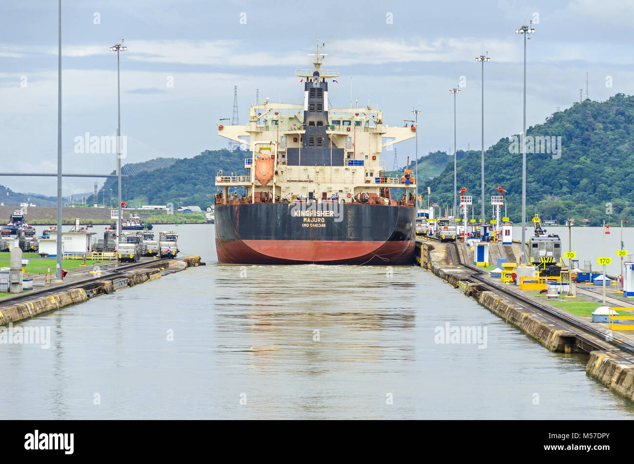 Panama City, Panama - 4 Novembre, 2017: Portarinfuse KINGFISHER appena passata attraverso il Miraflores Serrature con l aiuto di locomotive elettriche o mul Foto Stock