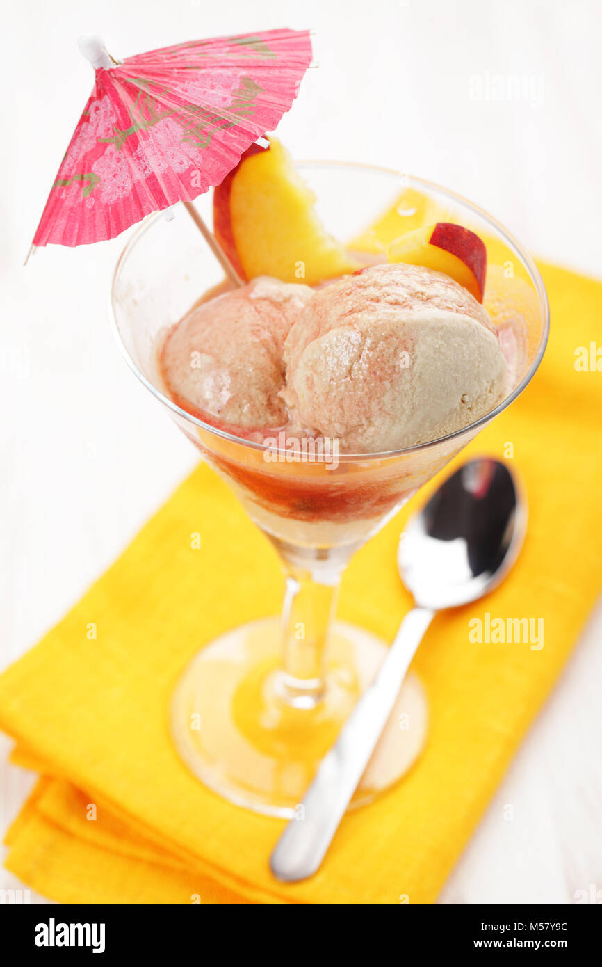Creme brulee gelato con pesche, sciroppo, e ombrellone Foto Stock