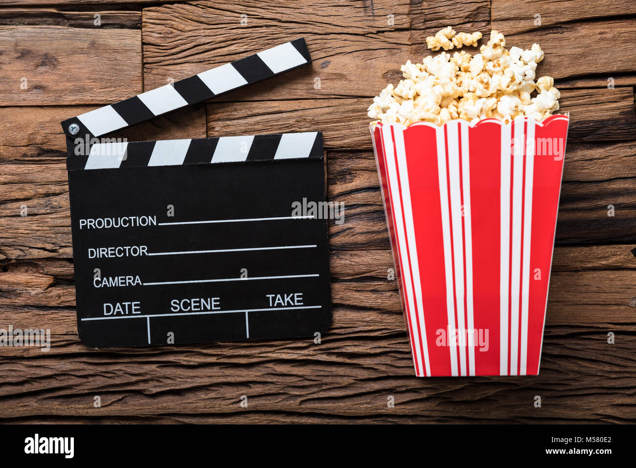 Primo piano della clapperboard e popcorn su legno che rappresenta il tempo del filmato Foto Stock