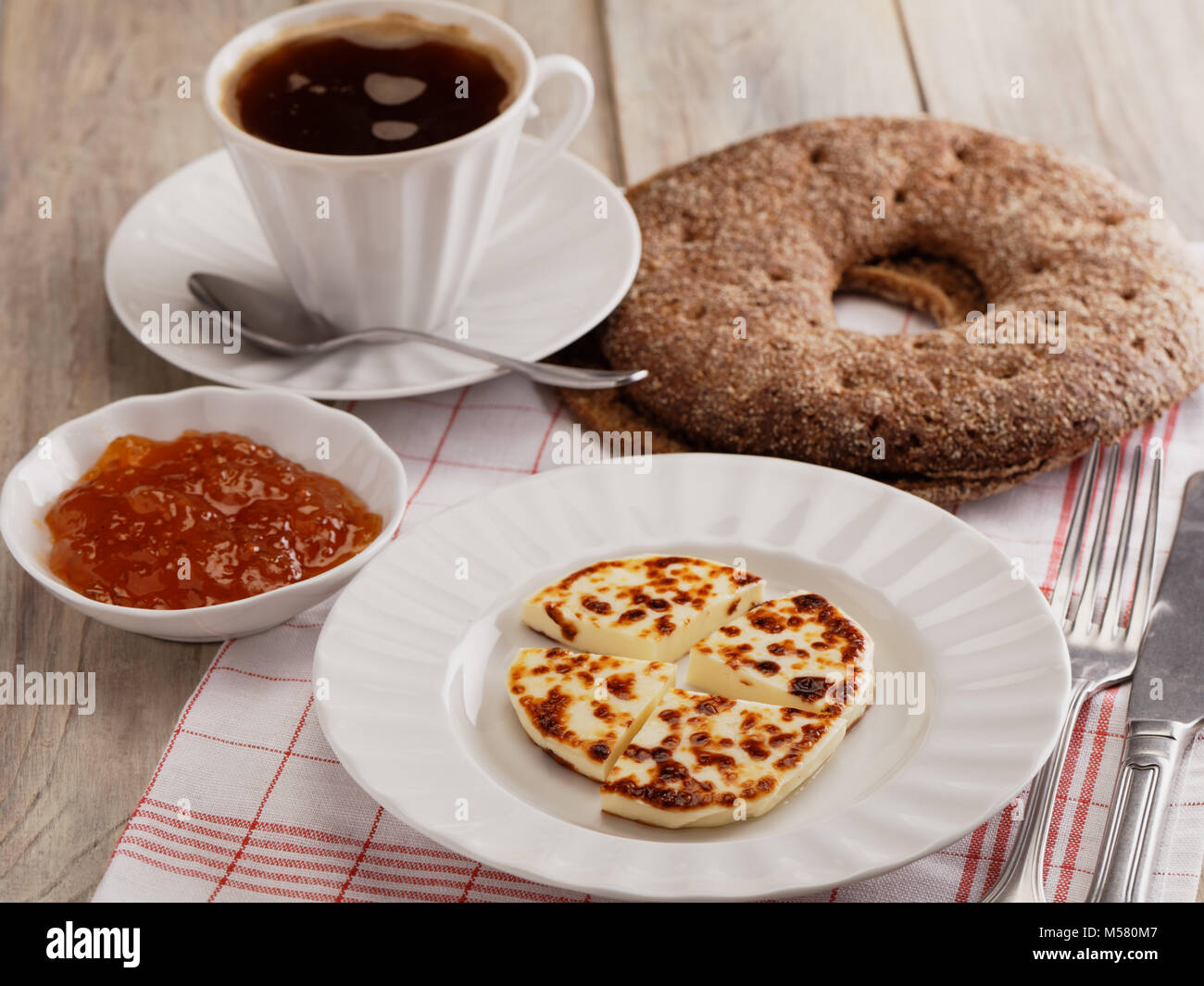 Il finlandese prima colazione con mini agricoltore formaggi Leipajuusto, cloudberry marmellata, foro pane e una tazza di caffè Foto Stock