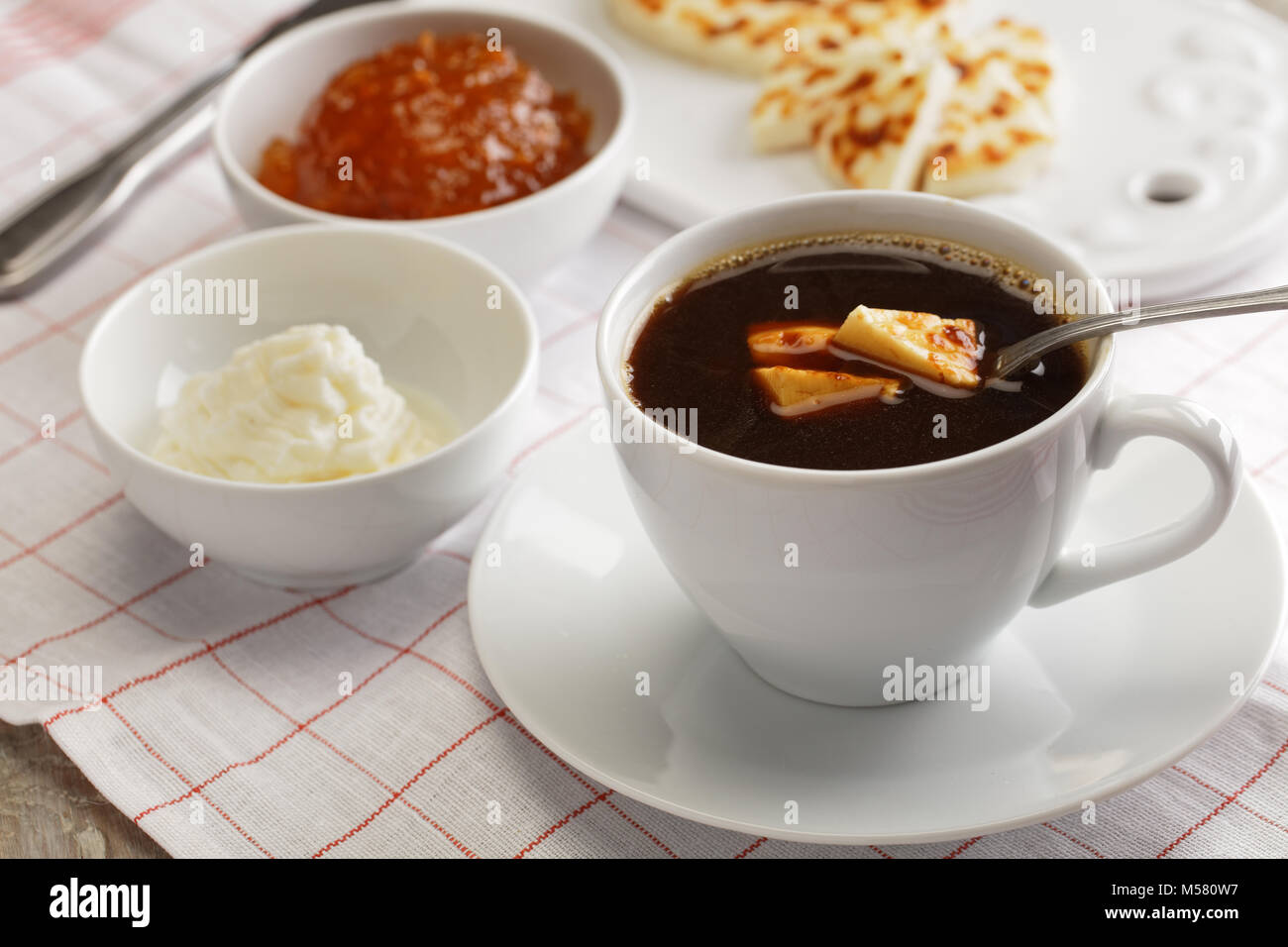 Colazione svedese con mini agricoltore formaggi, cloudberry marmellata, panna montata e una tazza di caffè Foto Stock