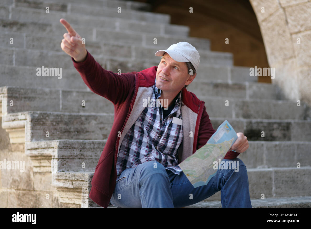Con Turismo Pianta della città seduto su una scala a Rodi Foto Stock