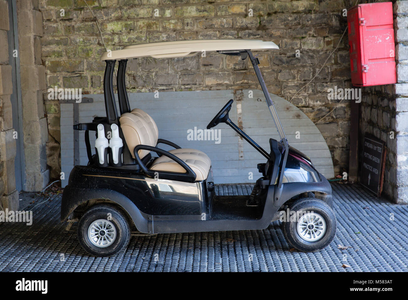 Parcheggiato nero golf elettrico carrello utilizzato per spostare intorno al campo da golf e trasportare attrezzature da golf Foto Stock