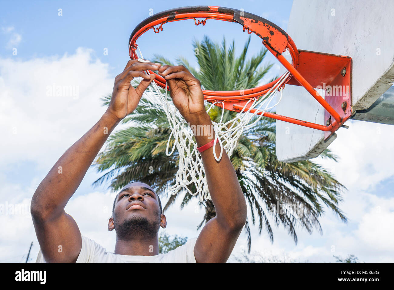 Miami Florida,Liberty City,African Square Park,centro città,basso reddito,povertà,maschio nero,teen teen teenager studenti studenti basket hoop Foto Stock