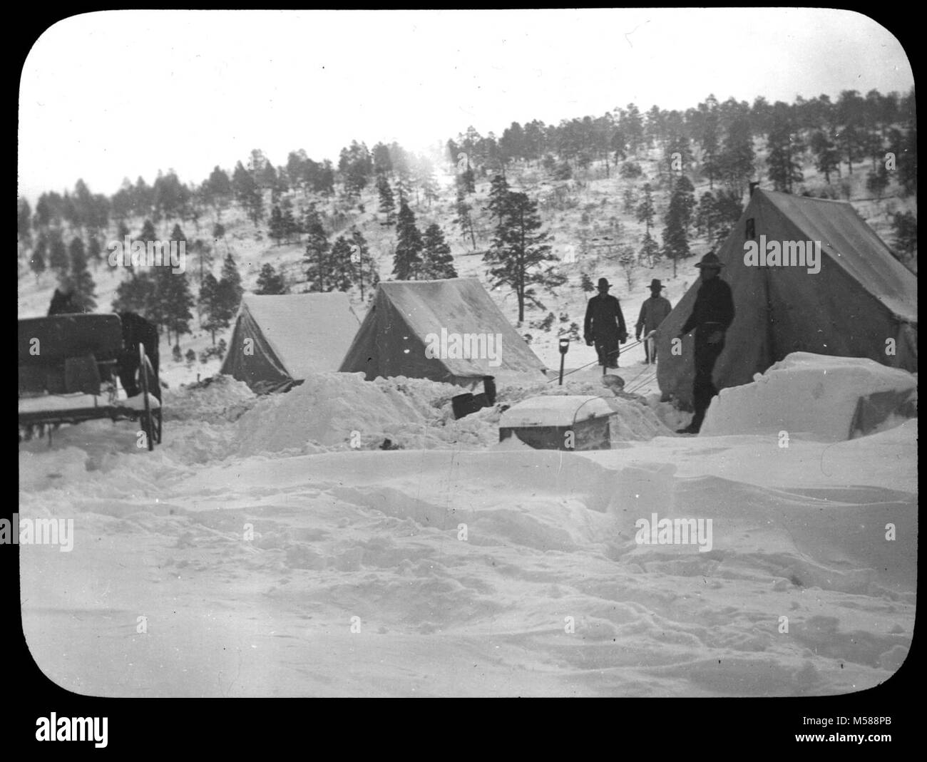 Grand Canyon Matthes indagine di campo invernale. Bianco e nero lanterna in vetro diapositiva che mostra tre tende, carro, e gli uomini nella neve. Collina con alberi e cespugli in background. Se sconosciuta al canyon USGS etichetta attaccata ma nessuna informazione circa 1902. Con un gruppo di diapositive da MATTHES sondaggio spedizione nel GRAND CANYON - circa 1902 Foto Stock