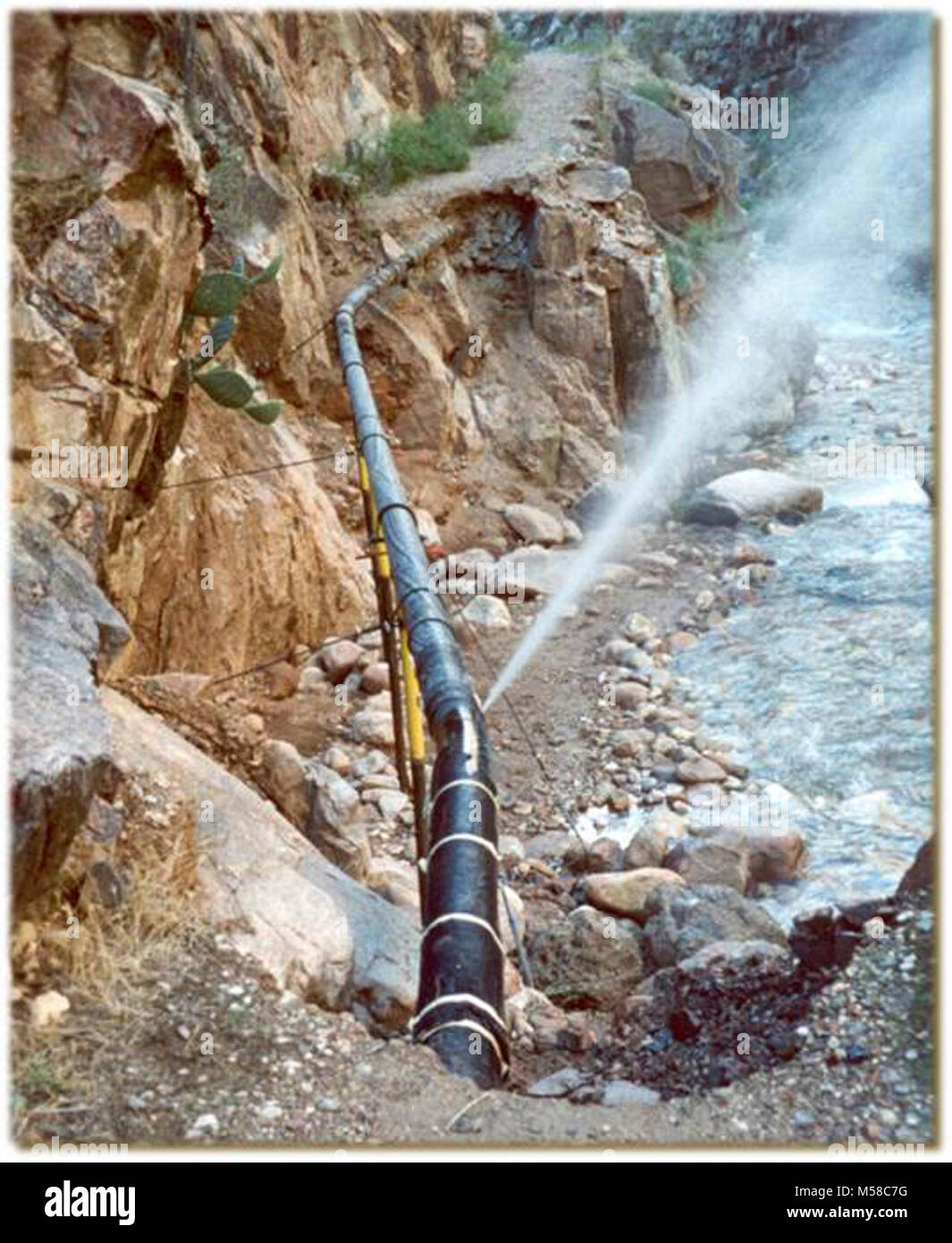 Parco Nazionale del Grand Canyon Trans Pipeline Canyon TCP. La spruzzatura di acqua da rompere in sezione esposta del Trans-canyon linea di galleggiamento - dopo il flash alluvione. Il Bright Angel Creek visibile sulla destra. (In questa zona, la pipeline è stato sepolto sotto la superficie del sentiero). Foto Stock