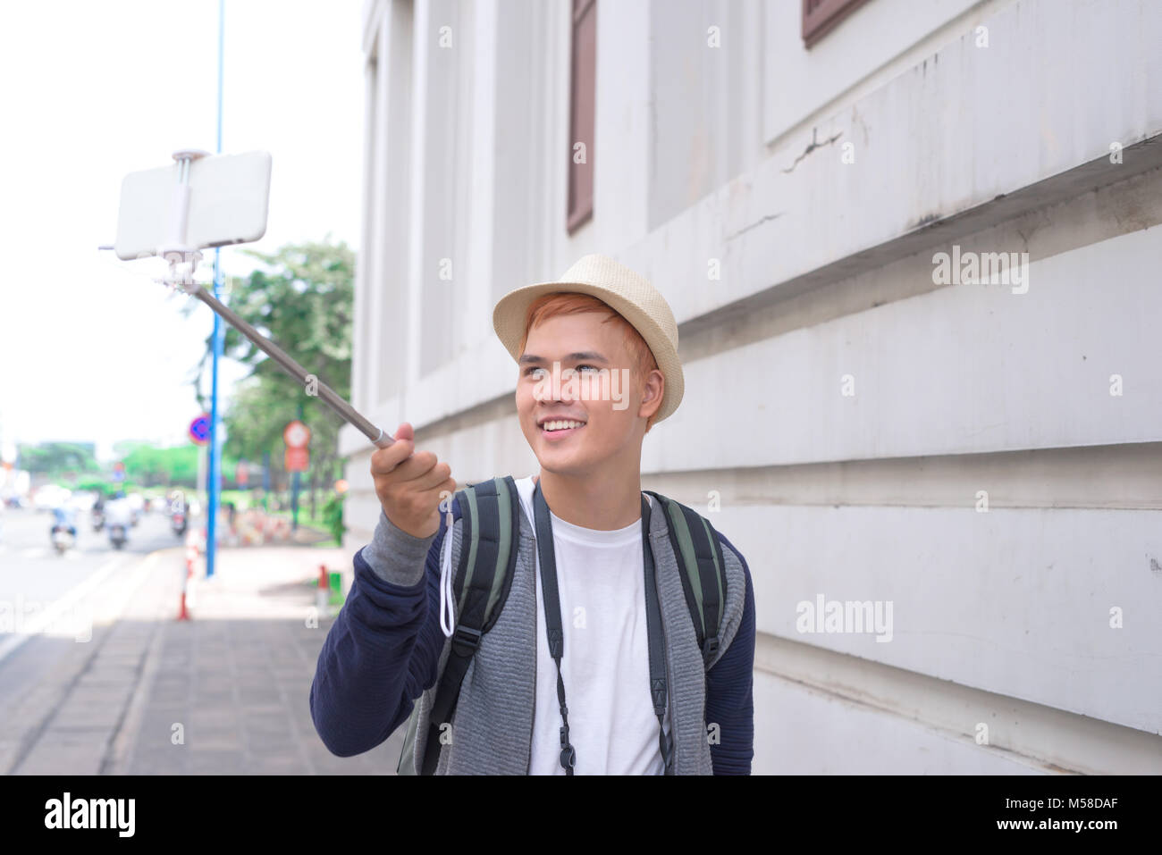 Asian giovane rendendo selfie con un bastone Foto Stock