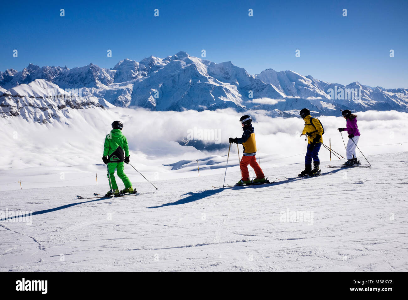 Gli sciatori sciare sulla neve sulle piste da sci con Mont Blanc come sfondo in Gran Massiccio nelle Alpi francesi. Tetes des Lindars Flaine Haute Savoie Rhone-Alpes Francia Foto Stock