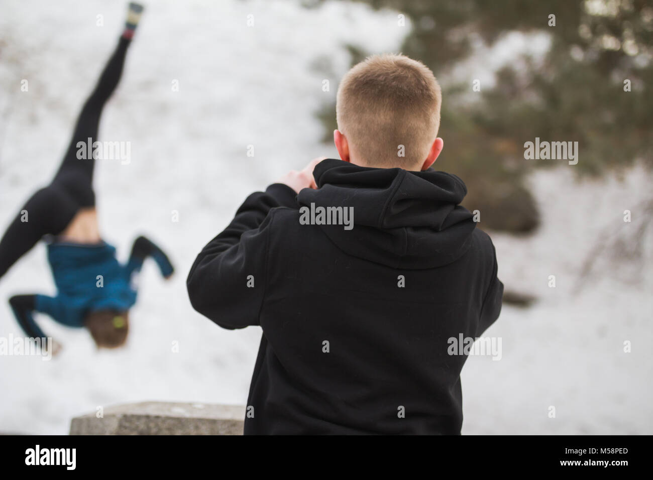 Adolescente prendere una foto per salto acrobatico ragazza in winter city park - Concetto di parkour Foto Stock