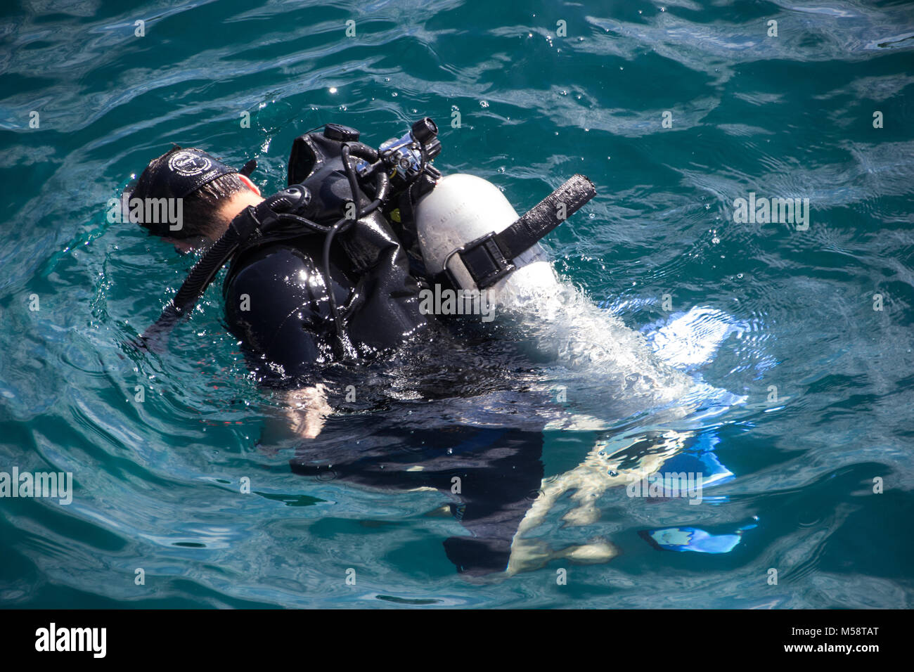 Scuba Diver imparare ad immergersi nel mare guardando sotto l'acqua Foto Stock