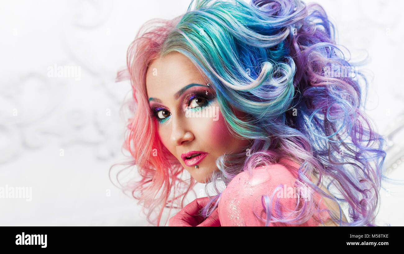 Bella donna con capelli luminosi. Capelli luminosi colori, acconciature con ricci. Foto Stock