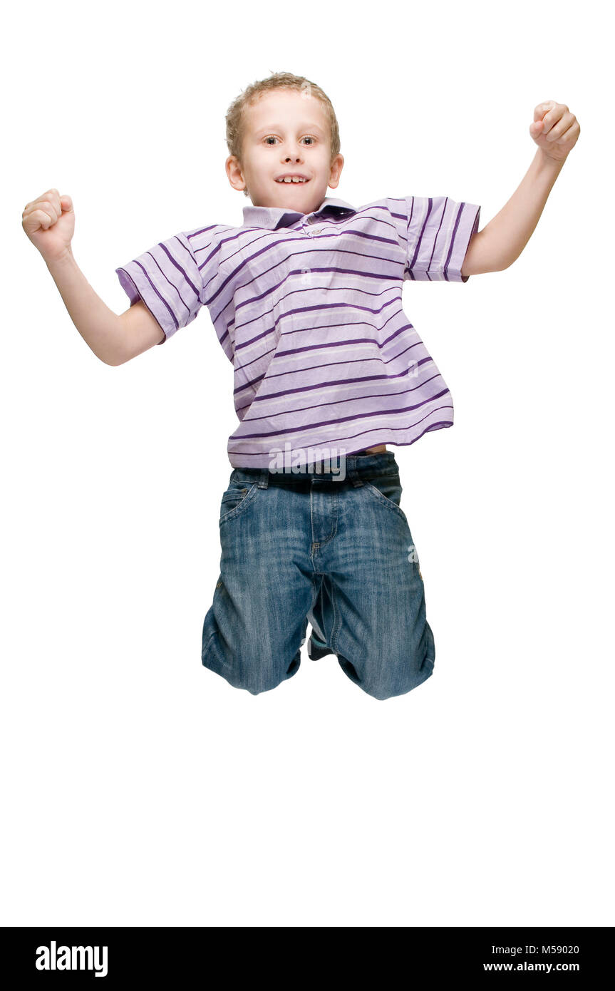 Frontale in piena vista del corpo di sette anni del ragazzo durante un salto in aria contro uno sfondo bianco. Foto Stock
