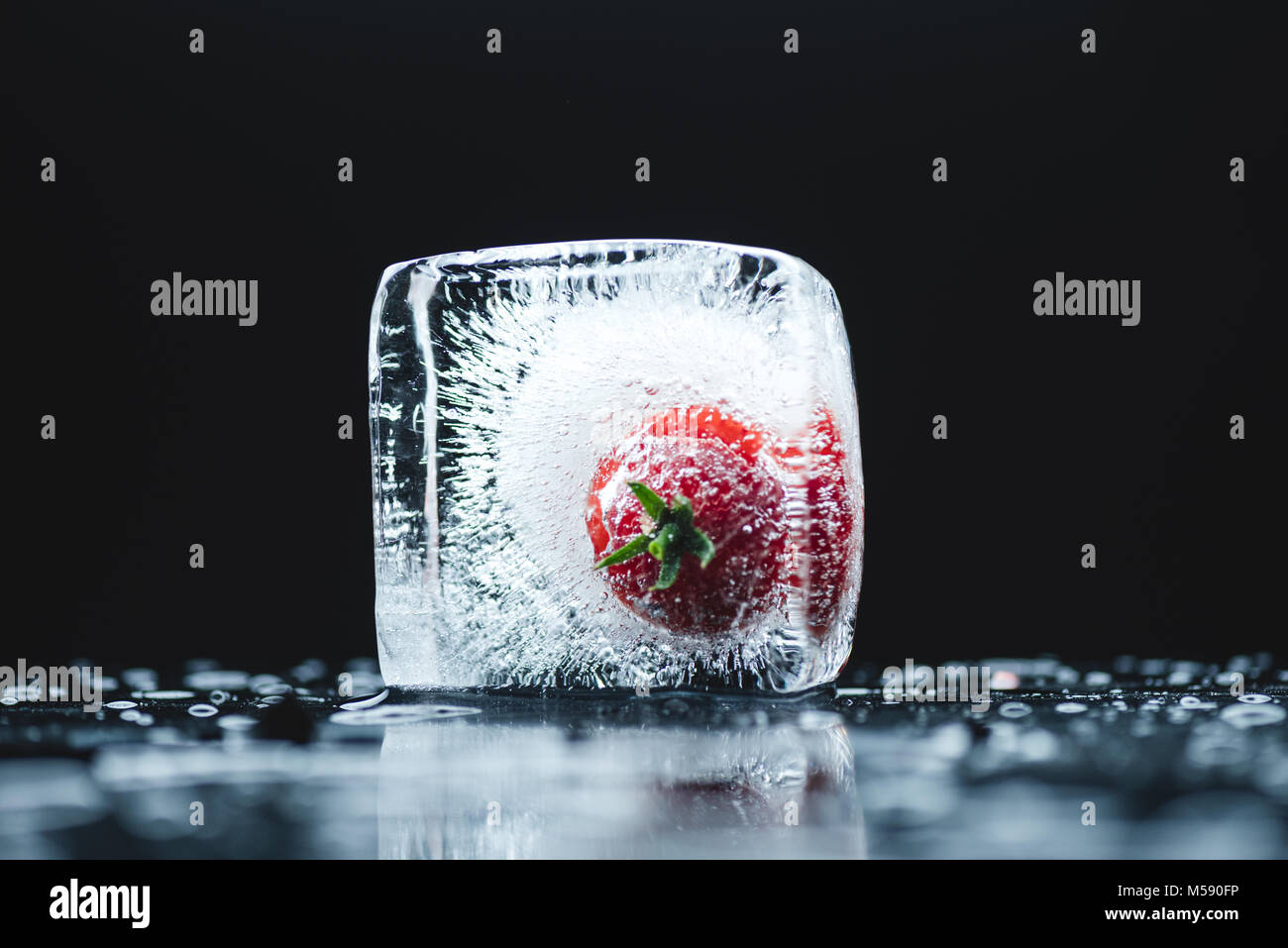 Pomodoro ciliegino nel cubo di ghiaccio Foto Stock