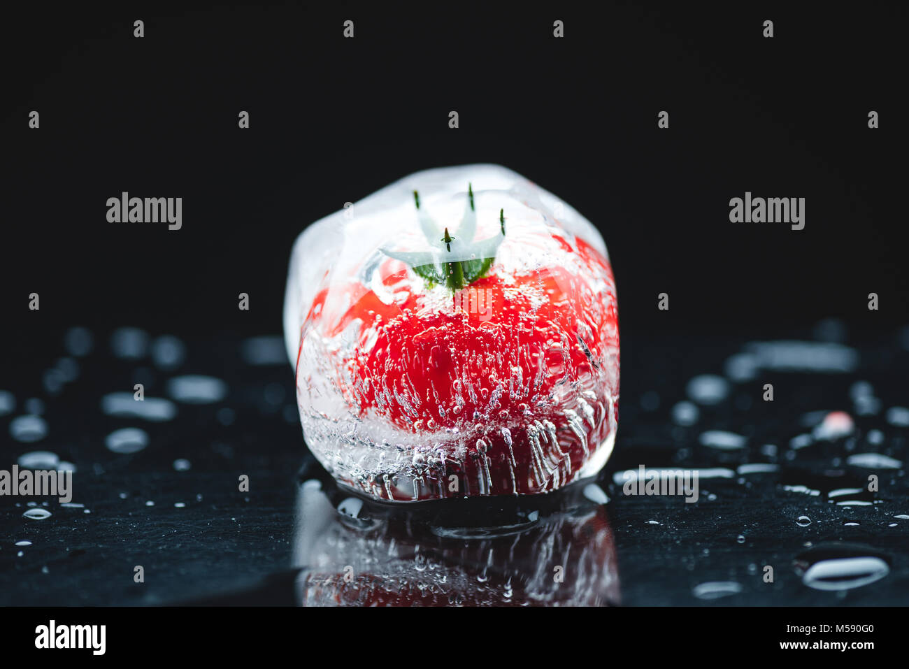Pomodoro ciliegino nel cubo di ghiaccio Foto Stock