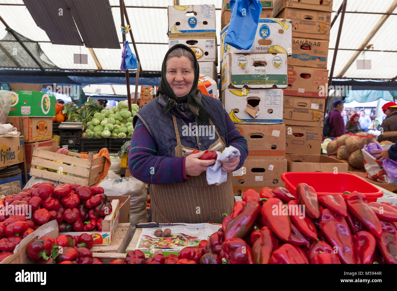 Donna rumena in vendita sul mercato peperoni e verdure Foto Stock