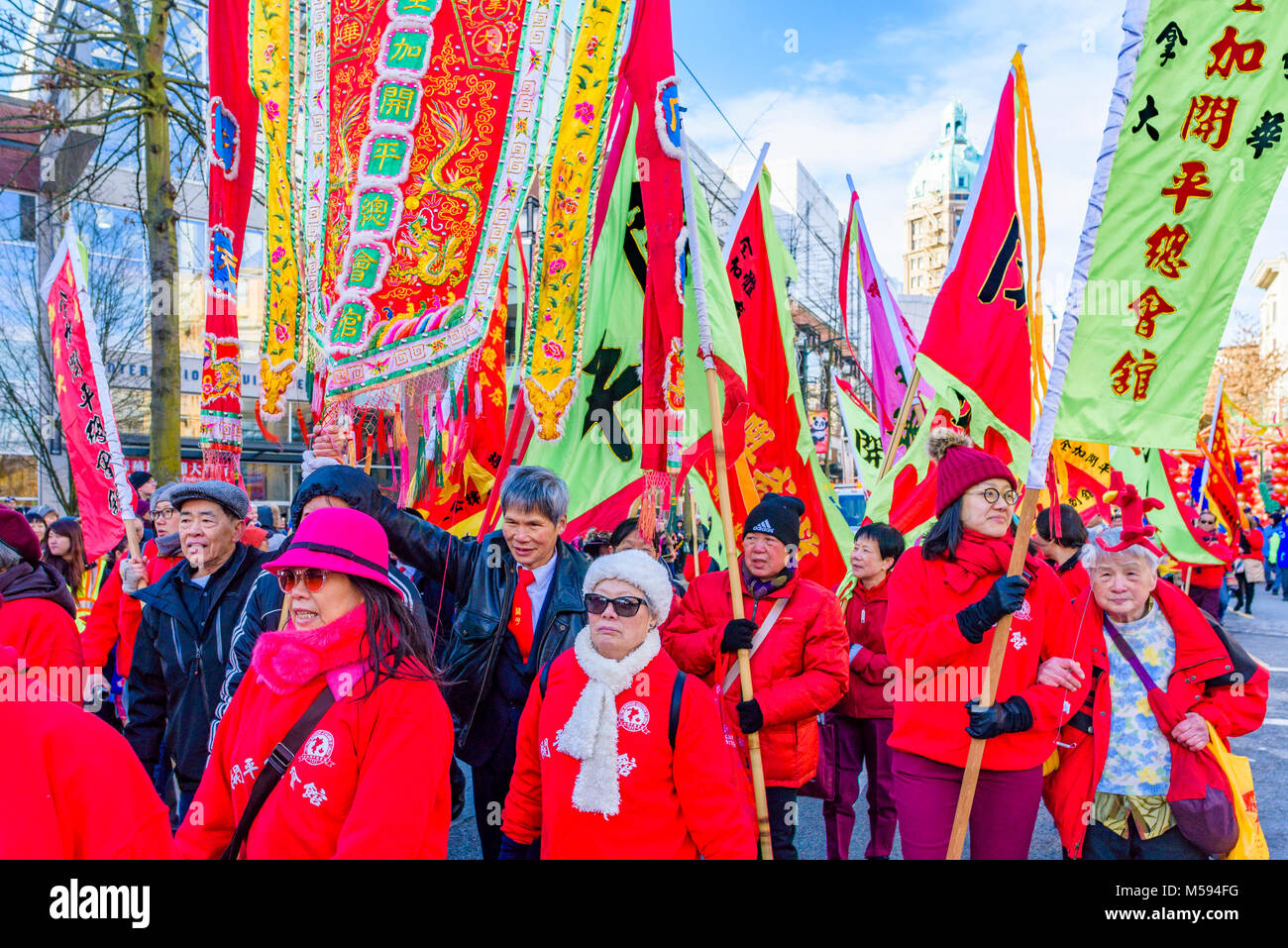 Hoy Ping Associazione benevola marzo con le bandiere al nuovo anno lunare cinese Parade, Chinatown, Vancouver, British Columbia, Canada. Foto Stock