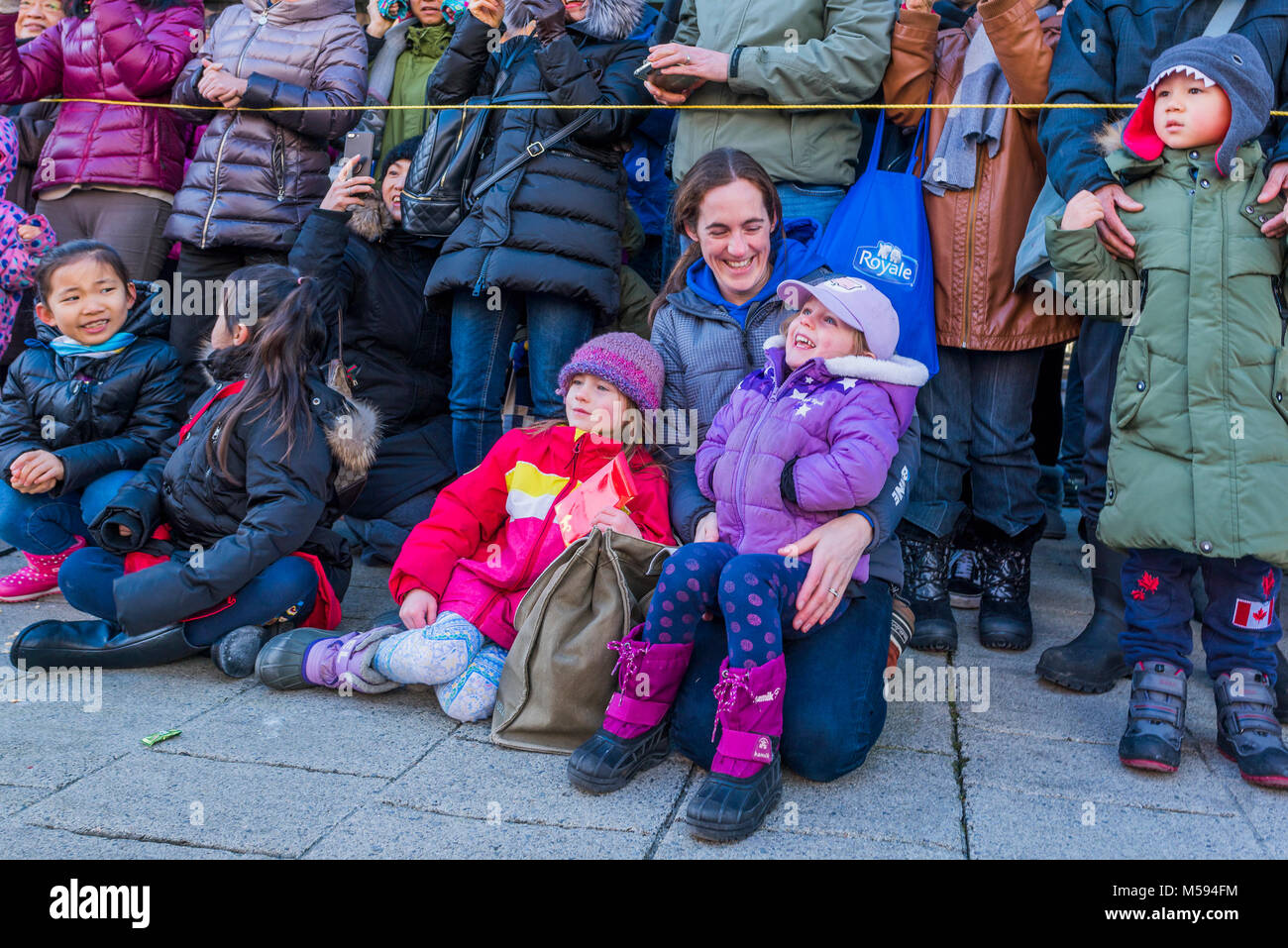Madre e figli godendo il nuovo anno lunare cinese Parade, Chinatown, Vancouver, British Columbia, Canada. Foto Stock