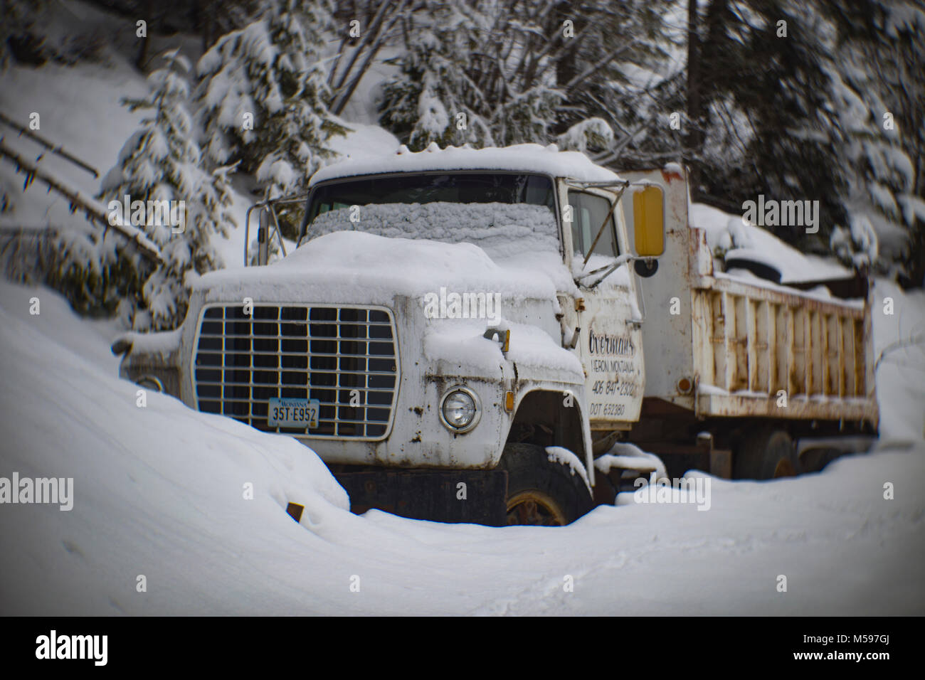 Una neve-corvered 1980 Ford L9000 autocarro con cassone ribaltabile lungo il lato della strada, ad Eagle View, Montana, girato con un antico 3¼ poll f/2,75 B&L Petzval lente. Foto Stock